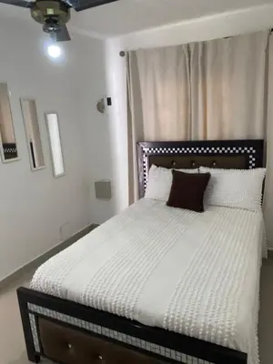 a bedroom with a bed with white sheets and brown pillows at Casa de campo Ana Victoria