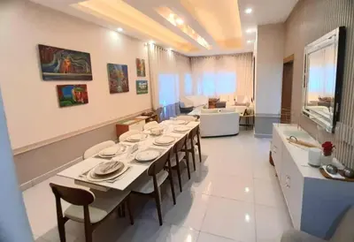 a dining room with a table and a living room at Luxury 3-Bedroom Apartment with Pool in Naco, Santo Domingo in Santo Domingo