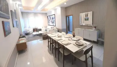a dining room with a table and a living room at Luxury 3-Bedroom Apartment with Pool in Naco, Santo Domingo in Santo Domingo