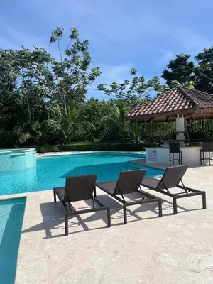 a swimming pool with two lounge chairs next to it at Private Rooftop Penthouse Near Coson Beach Jacuzzi and BBQ in Las Terrenas