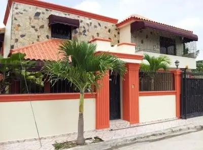 a house with a palm tree in front of it at Casamesa-14 in Los Alcarrizos