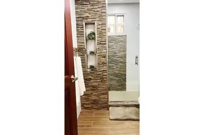 a door leading into a hallway with a brick wall at Cubana Stays in Santiago de los Caballeros