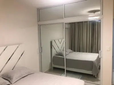 a bedroom with two beds and a mirror at Apartamento acogedor en Santo Domingo este in Hainamosa