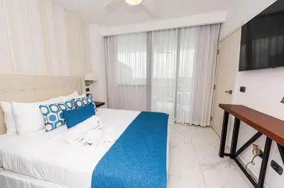 a bedroom with a large bed with blue and white pillows at Luxury 2BR, Private Jacuzzi, CanaRock Star in Punta Cana