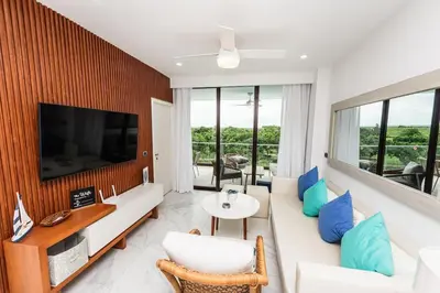 a living room with a white couch and a tv at Luxury 2BR Private Jacuzzi CanaRock Star Punta Cana in Punta Cana