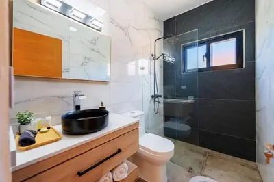a bathroom with a sink and a toilet and a shower at Villa Sunrise an elegant private villa in Central Sosua in Sosúa