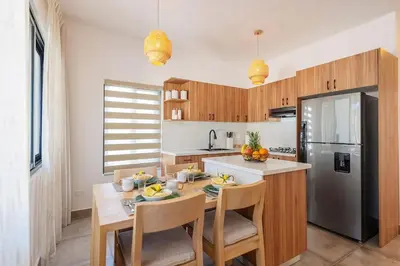 a kitchen with a table with chairs and a refrigerator at Villa Sunrise an elegant private villa in Central Sosua in Sosúa