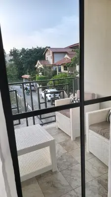 a view of a balcony with a table and benches at Encuentro Vaquero in Jarabacoa