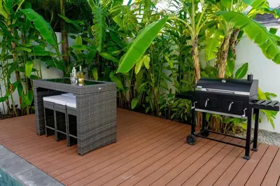 a bbq and a grill on a wooden deck at Playa Bonita Fully Serviced Villa - Walk to Beach in Las Terrenas