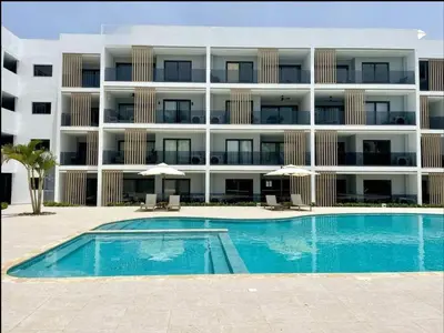 a large apartment building with a swimming pool in front of it at Beautiful apartment Bavaro Beach in Punta Cana