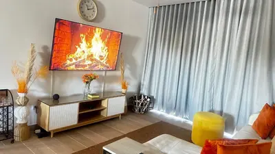 a living room with a fire painting on the wall at Beautiful apartment Bavaro Beach in Punta Cana