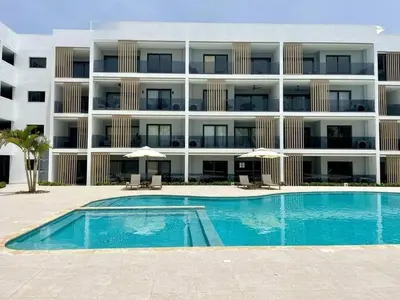 a swimming pool in front of a large apartment building at Beautiful apartment Bavaro Beach in Punta Cana