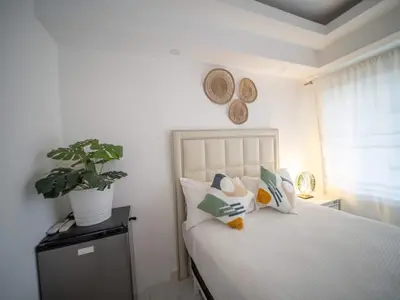 a bedroom with a bed with pillows and a potted plant at Room in Sosua center with Outdoor Jacuzzi in Sosúa