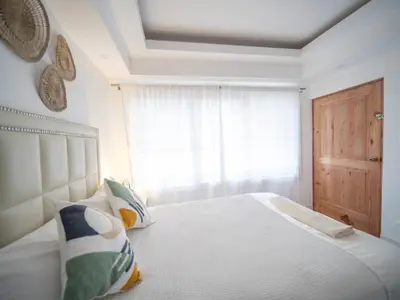 a bedroom with a white bed with a window at Room in Sosua center with Outdoor Jacuzzi in Sosúa