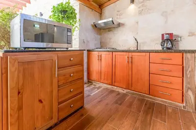 a kitchen with wooden cabinets and a microwave at Room in Sosua center with Outdoor Jacuzzi in Sosúa