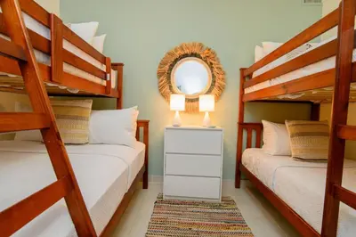 a bedroom with two bunk beds and a mirror at Stunning Beachfront 2BR Condo in Juan Dolio in Juan Dolio