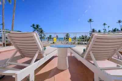 two chairs and a table on a balcony with the ocean at Stunning Beachfront 2BR Condo in Juan Dolio in Juan Dolio