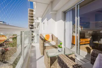 a balcony with chairs and a table on a building at Cozy 3BR Condo in Ens. Ozama in La Cruz de Mendoza