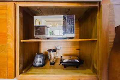 a kitchen with a microwave and a blender in a cabinet at Cozy 3BR Condo in Ens. Ozama in La Cruz de Mendoza