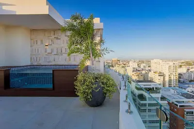 a balcony of a building with two palm trees on it at Luxury City Center Condo, Roof Top Jacuzzi in Santo Domingo