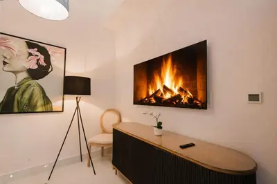 a fireplace in a living room with a table and a fire place at Luxury City Center Condo, Roof Top Jacuzzi in Santo Domingo
