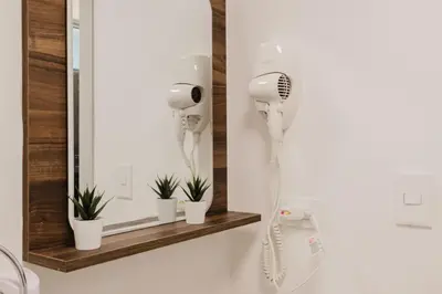 a bathroom with a hair dryer and a mirror at Luxury City Center Condo, Roof Top Jacuzzi in Santo Domingo