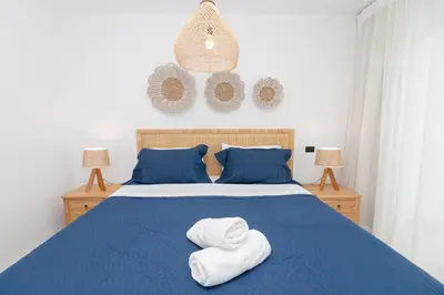 a bedroom with a blue bed with towels on it at Elegant 1-BD Luxury Escape in Paradise in Estrella