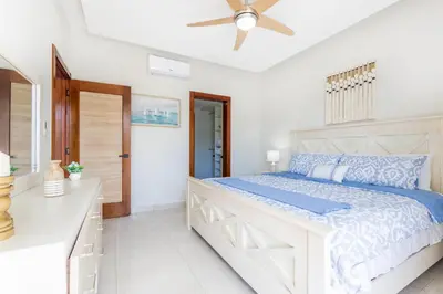 a bedroom with a large bed and a ceiling fan at Stylish 1BR Apartment Near Bávaro Beach, Pool View in Punta Cana