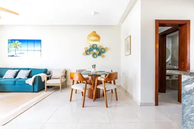 a dining room and living room with a table and chairs at Stylish 1BR Apartment Near Bávaro Beach, Pool View in Punta Cana