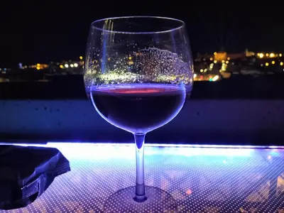 a glass of wine sitting on top of a table at Apartamento con tres habitaciones, piscina y parking techado gratis in Juan López