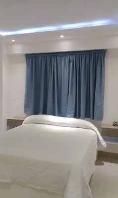 a bedroom with a window with a blue curtain at Apartamento con tres habitaciones, piscina y parking techado gratis in Juan López
