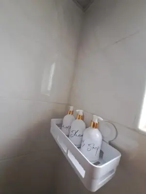three white bottles in a shelf in a bathroom at Luxurious and comfortable in the safest area in Juan López