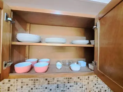 a cupboard with bowls and plates in it at Luxurious and comfortable in the safest area in Juan López