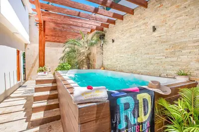 a swimming pool in a room with a brick wall at Room in Sosua With Nice Jacuzzi in Sosúa