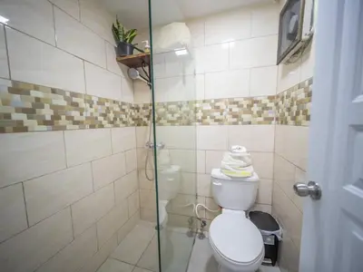 a bathroom with a toilet and a glass shower at Studio In Sosua Center Strip Zone in Sosúa
