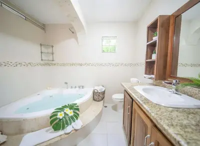 a bathroom with a tub and a toilet and a sink at Spacious 1BR APT in Sosua strip in Sosúa