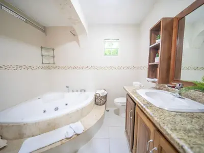 a bathroom with a tub and a sink and a toilet at Spacious 1BR APT in Sosua strip in Sosúa
