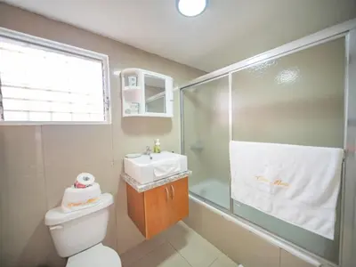 a bathroom with a toilet and a sink and a shower at Cozy & Central 3BR Apt Secure & Comfortable in Sosúa