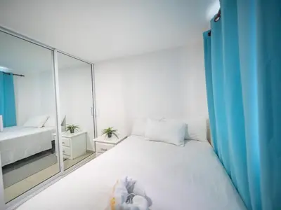 a bedroom with a white bed and a mirror at Cozy & Central 3BR Apt Secure & Comfortable in Sosúa