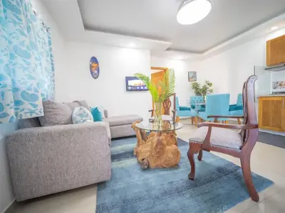 a living room with a couch and a table and a chair at Cozy & Quiet 1BT Apt Central in Sosua in Sosúa