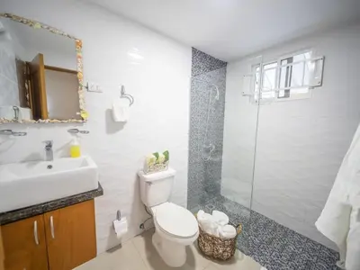 a bathroom with a toilet and a sink and a shower at Stylish 1BR Near Beach & Main Strip Sosua in Sosúa