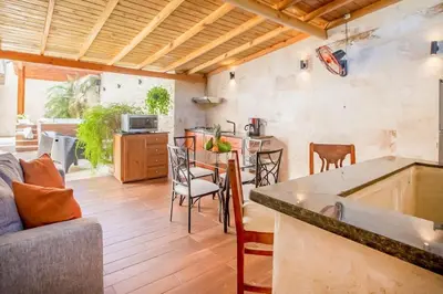 a kitchen and living room with a table and chairs at Room in the center with Outdoor Jacuzzi in Sosúa