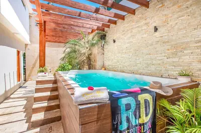 a swimming pool in a room with a brick wall at Room in the center with Outdoor Jacuzzi in Sosúa