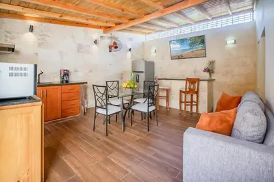 a kitchen and a living room with a table and chairs at Room in the center with Outdoor Jacuzzi in Sosúa