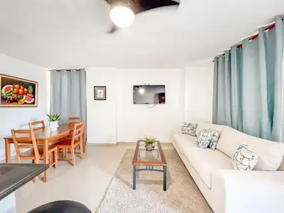 a living room with a white couch and a table at Secure and Central 2BR Apt in Sosúa