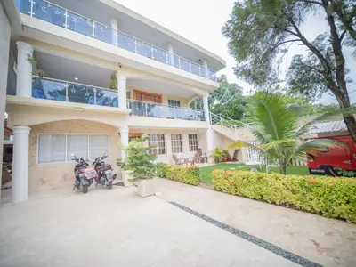 a house with two motorcycles parked in front of it at Secure and Central 2BR Apt in Sosúa
