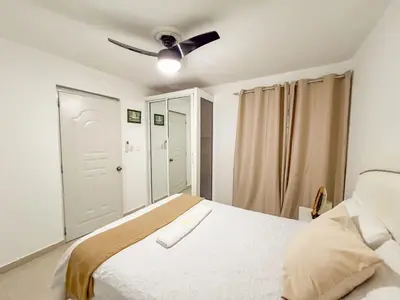 a bedroom with a bed with a ceiling fan at Secure and Central 2BR Apt in Sosúa