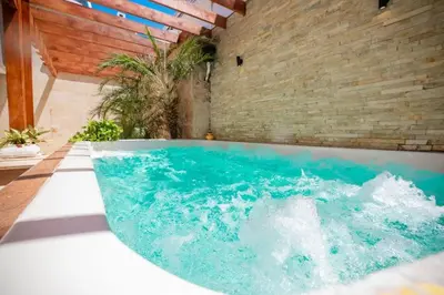 a hot tub in a room with a brick wall at Getaway room with shared Jacuzzi in the center in Sosúa