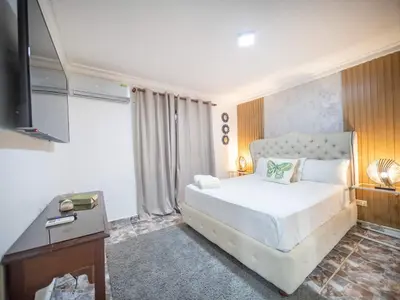 a bedroom with a white bed and a television at Affordable 1BR APT in Sosua Center - Strip Zone in Sosúa