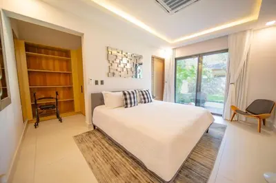 a bedroom with a large white bed and a window at Luxury villa with Private beach access in Sosúa